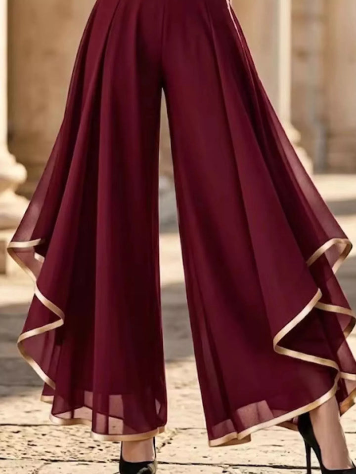 Burgundy wide leg pants with draped ruffle overlay, lower body view with heels