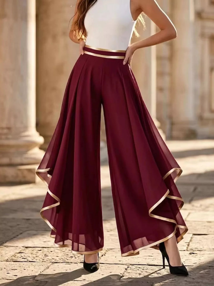 Women's burgundy high waisted wide leg pants with sheer asymmetric ruffle overlay