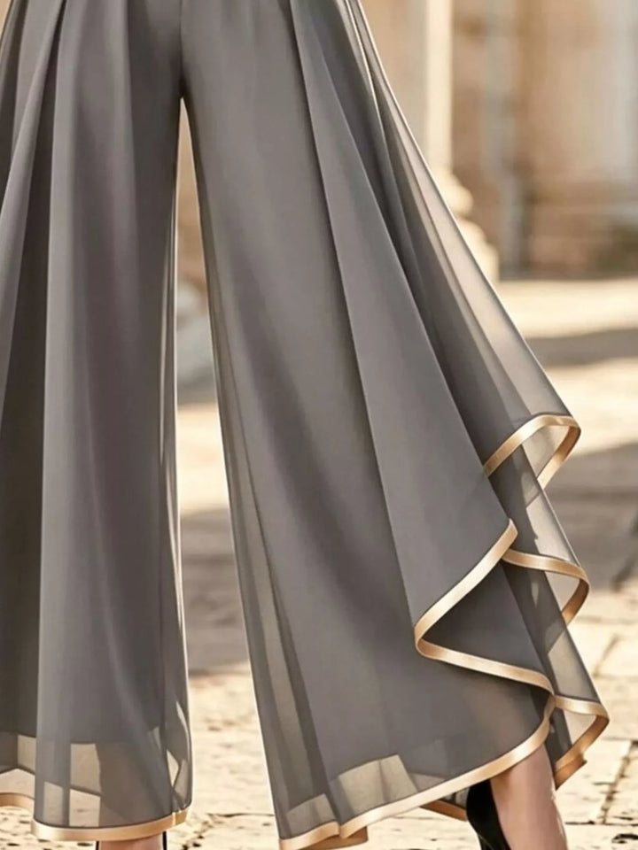 Close-up of the gray sheer overlay draping over the wide legs