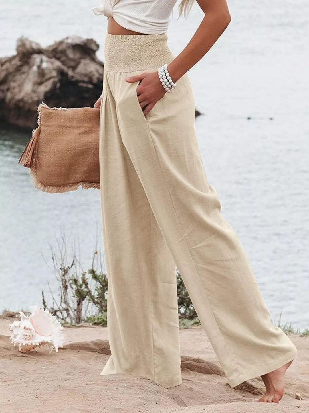 Light sand wide leg pants in a walking side pose with hand in pocket