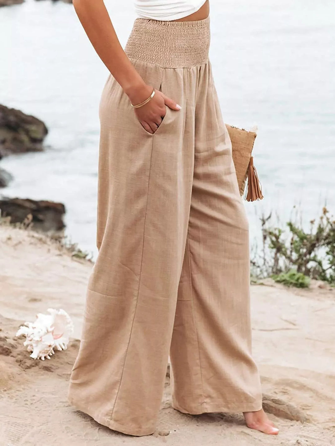 Sand toned high waisted pants with hand in pocket, angled view