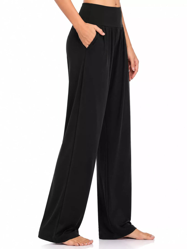 Black high waisted wide leg pants, side view with pocket and bare feet