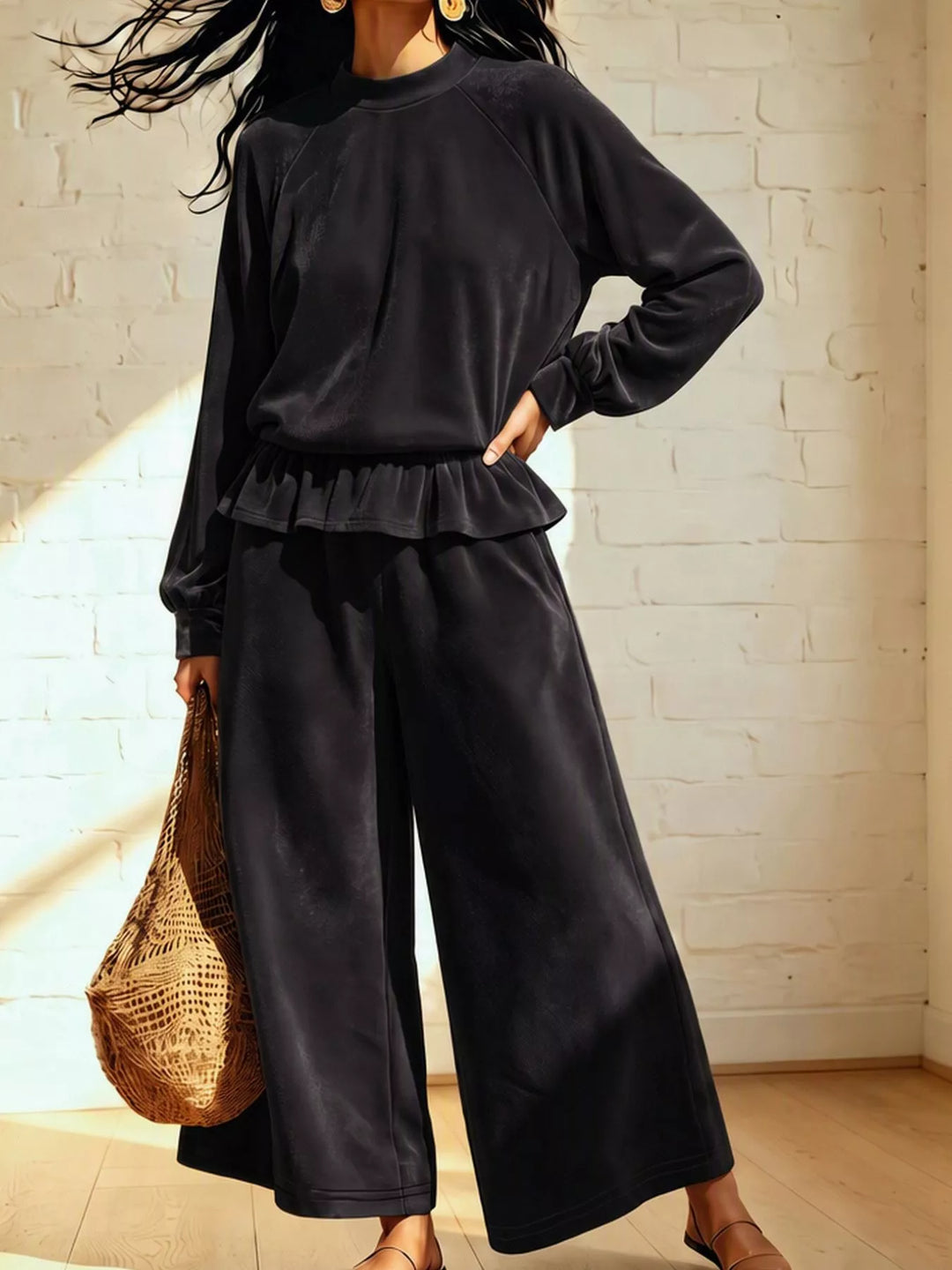 Black peplum top and wide leg pants with hand on hip, styled with a basket bag