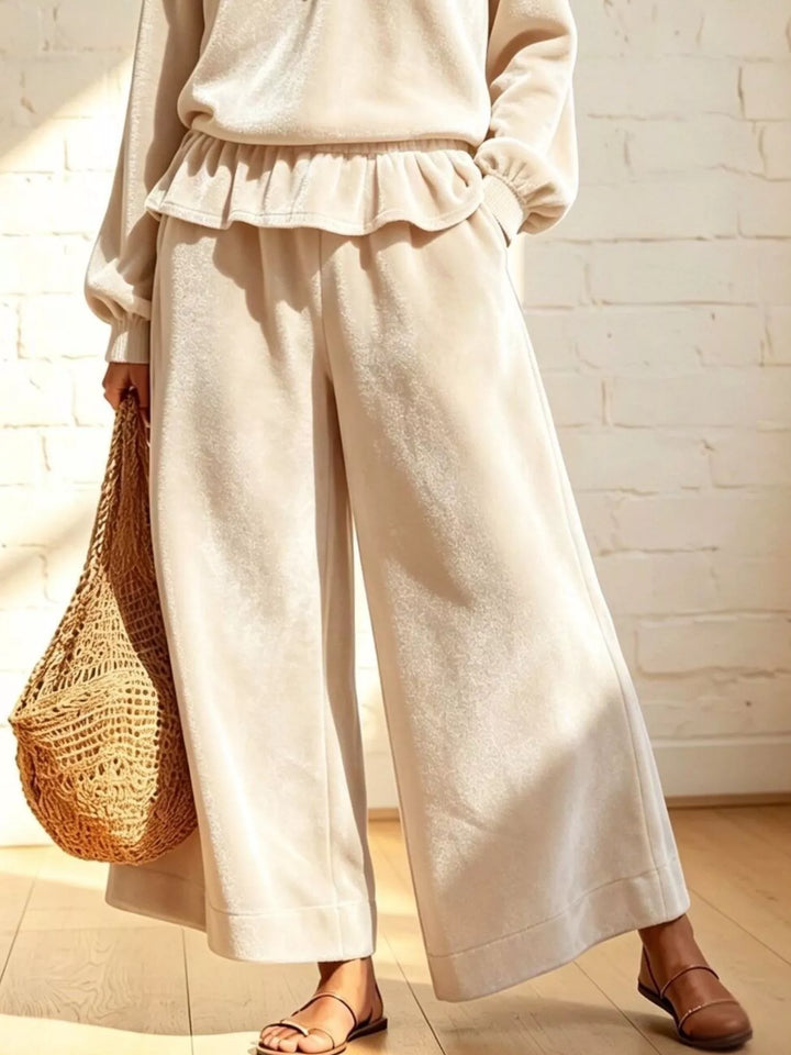Cream peplum top and wide leg pants styled with a woven basket bag