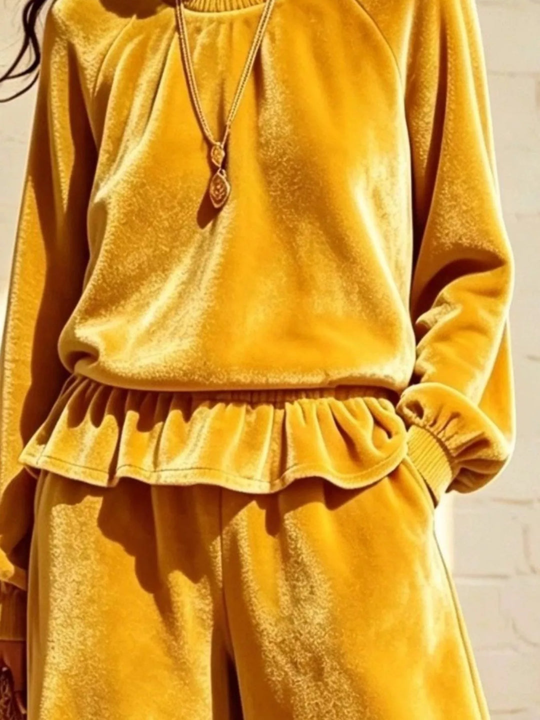 Close-up of the mustard peplum hem and gathered raglan sleeves