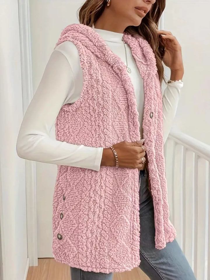 Blush pink fluffy vest in a side turn, worn open over a white top