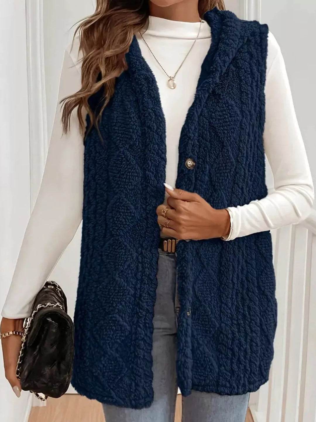 Navy longline fluffy vest with a black handbag, front view
