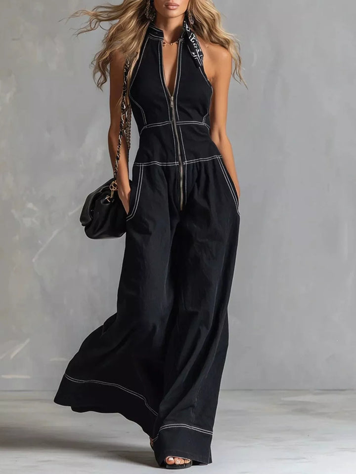 Women's jumpsuit in black, halter neck wide leg zip front, full-length walking pose