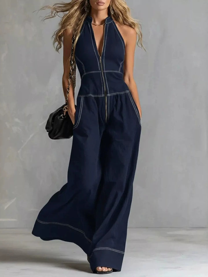 Navy halter neck jumpsuit with wide legs and a front zip, walking pose