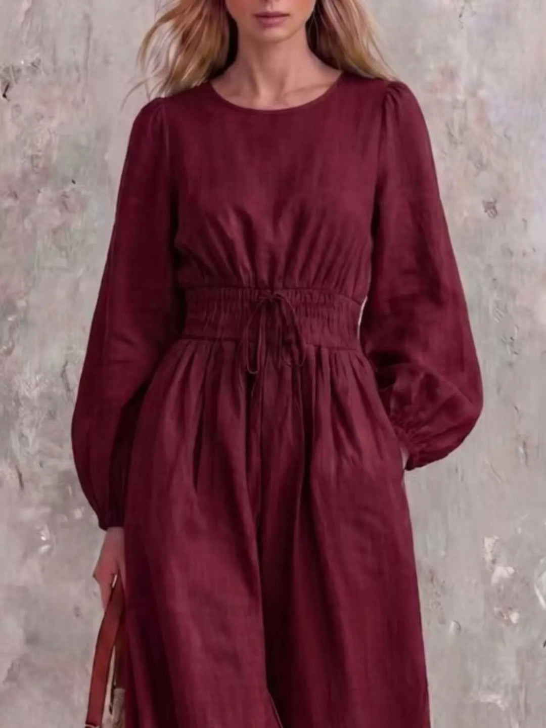 Burgundy jumpsuit with cinched waist and round neckline, closer front view