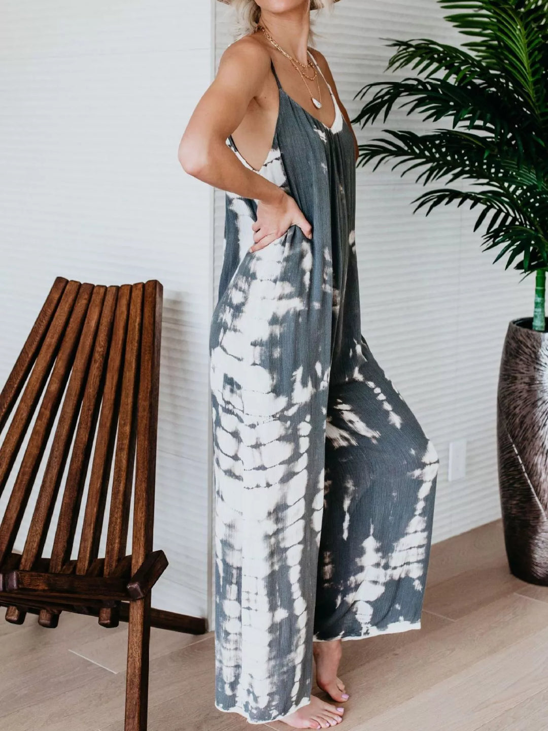 Gray tie dye jumpsuit from the side, one hand in the pocket