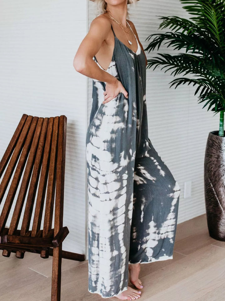 Gray tie dye jumpsuit from the side, one hand in the pocket