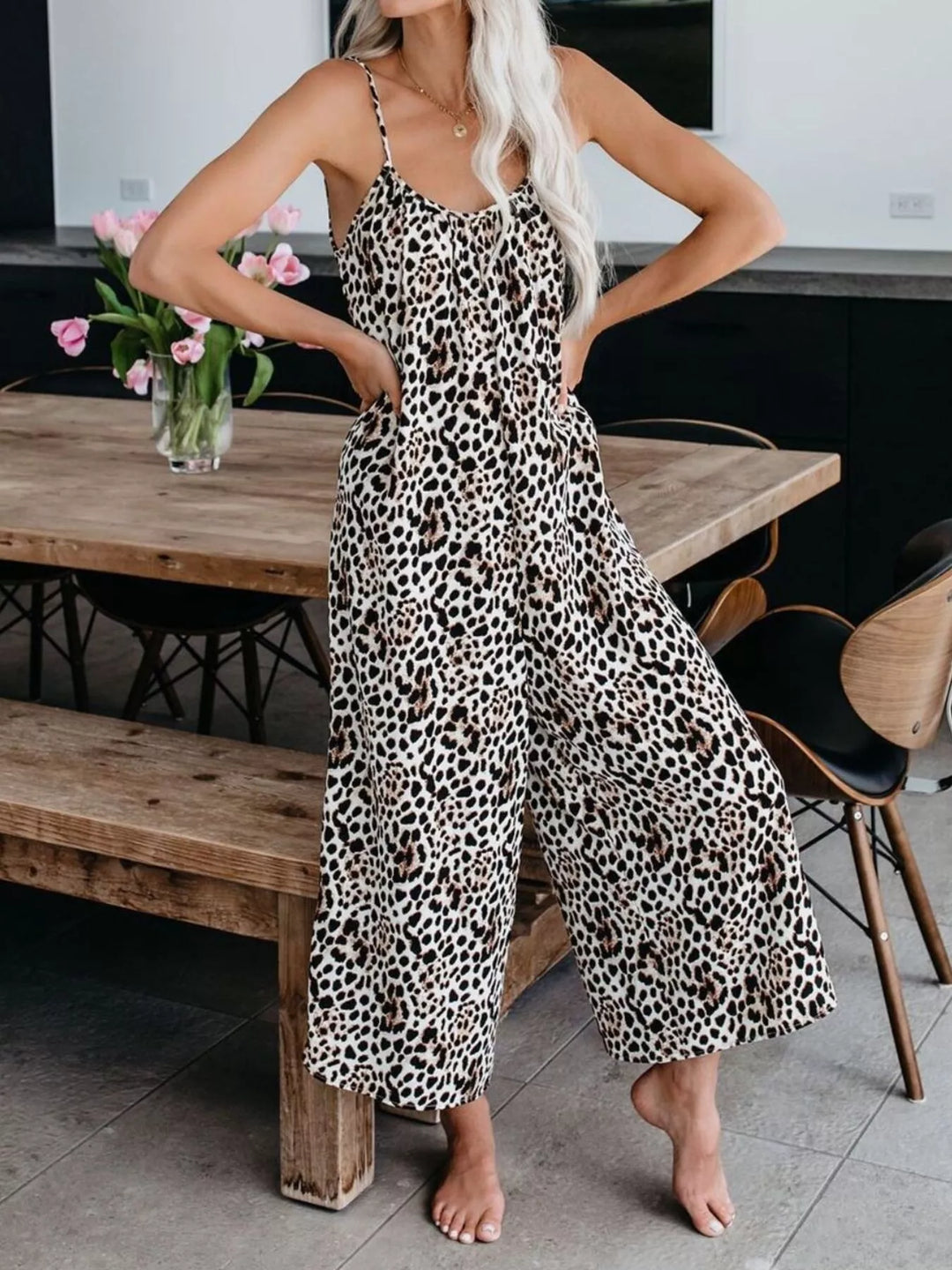 Leopard jumpsuit worn with hands on hips, wide legs flowing