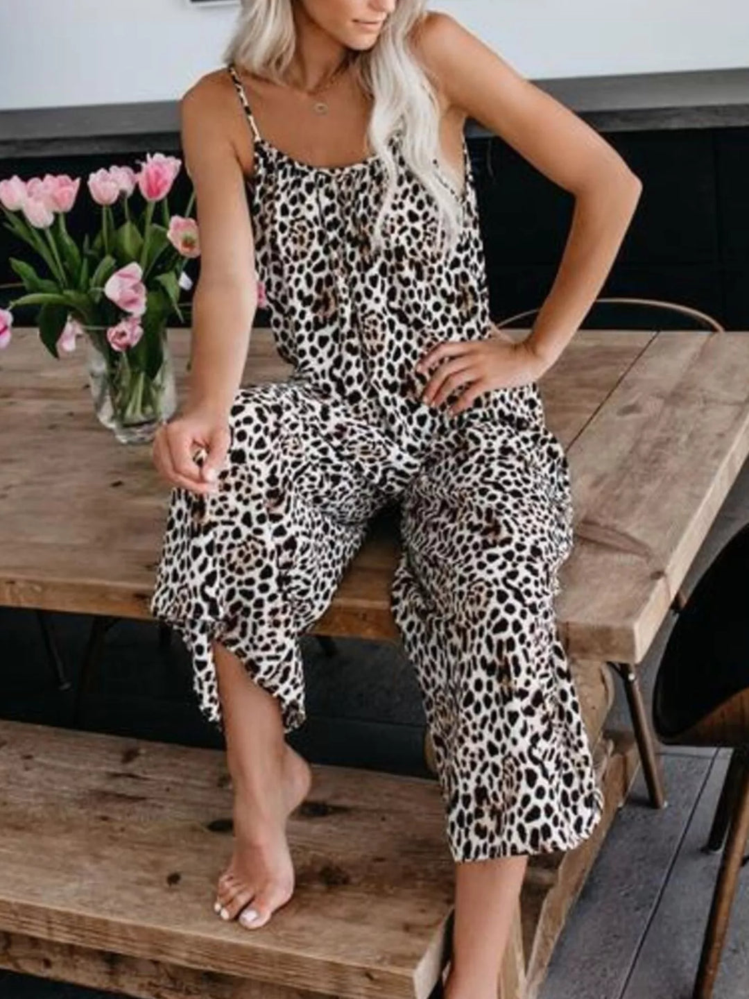 Leopard print jumpsuit, model seated on a wooden bench