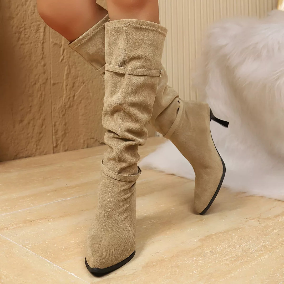 Beige slouchy kitten heel boots with pointed toe, worn standing