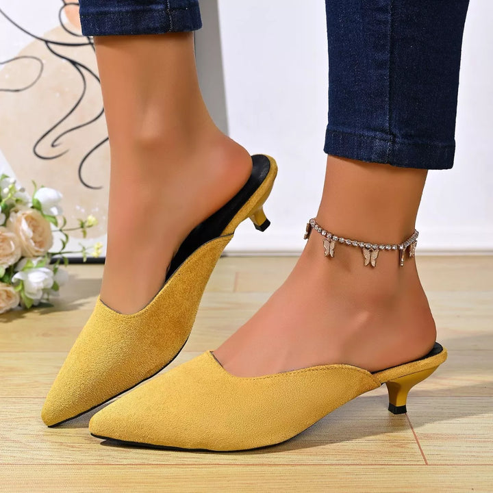 Mustard pointed toe kitten heel mules worn with ankle chain and jeans