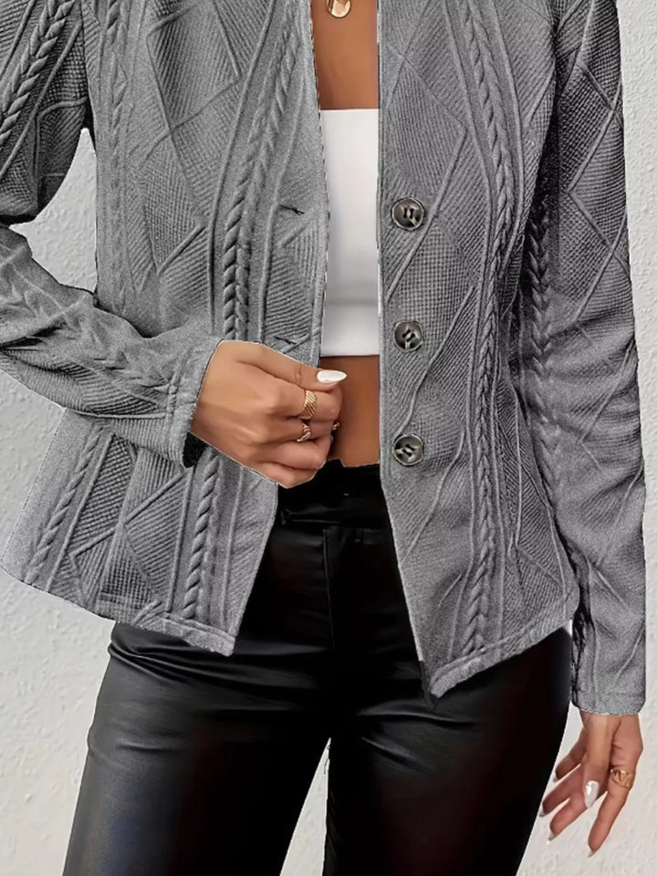 Detail of the dark gray knit blazer button front worn over a white top