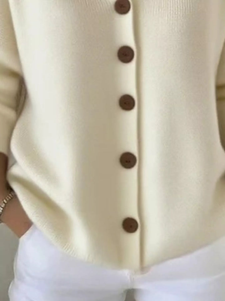 Detail of the cream cardigan button front and ribbed hem