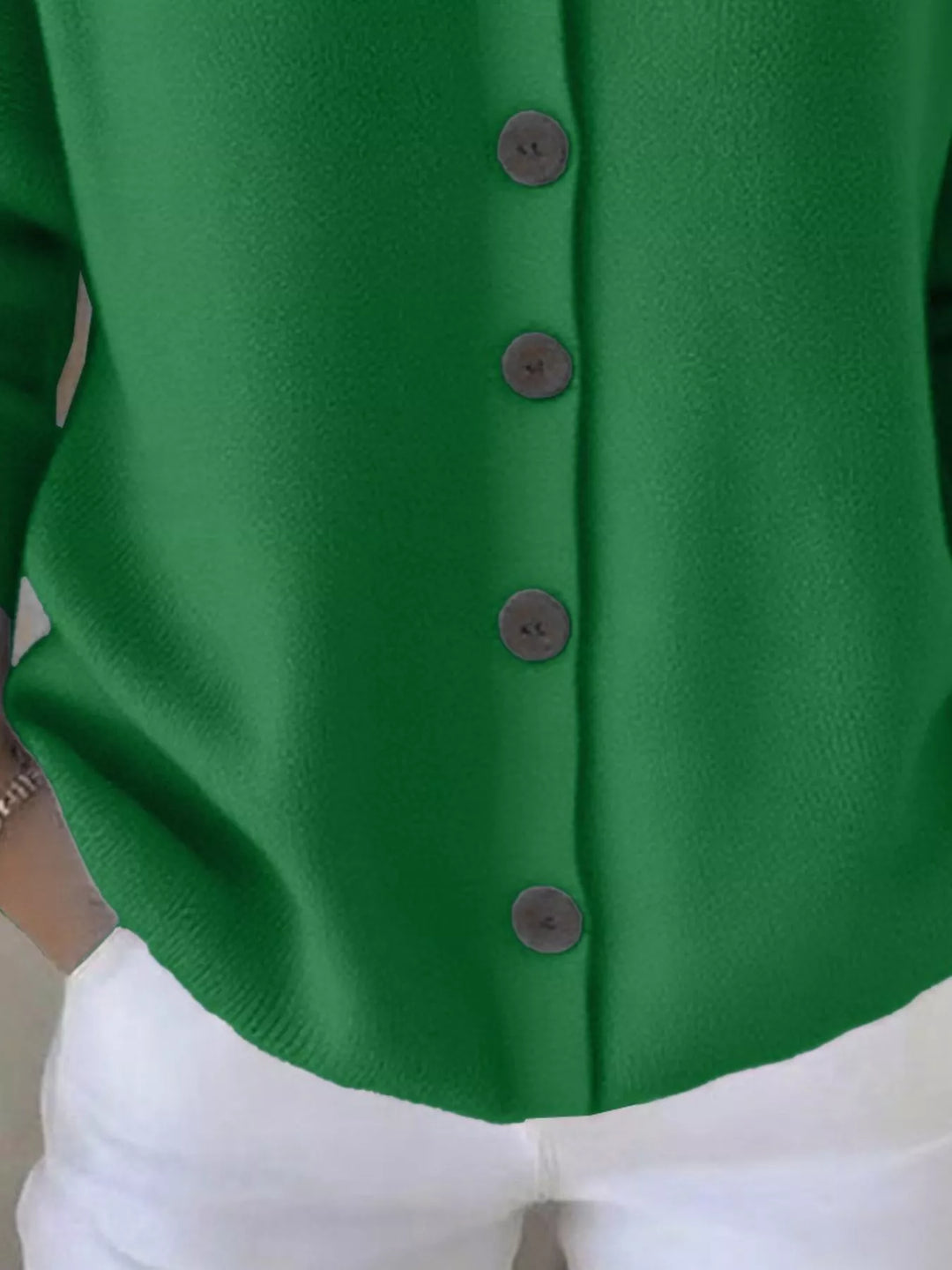 Detail of the green cardigan button front and ribbed hem