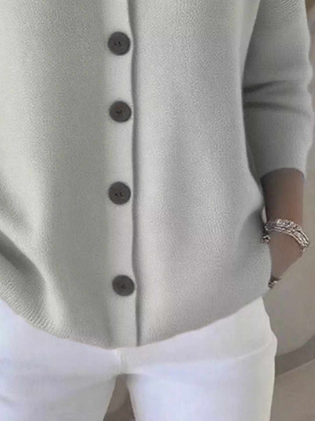 Detail of the light gray cardigan button front and ribbed hem