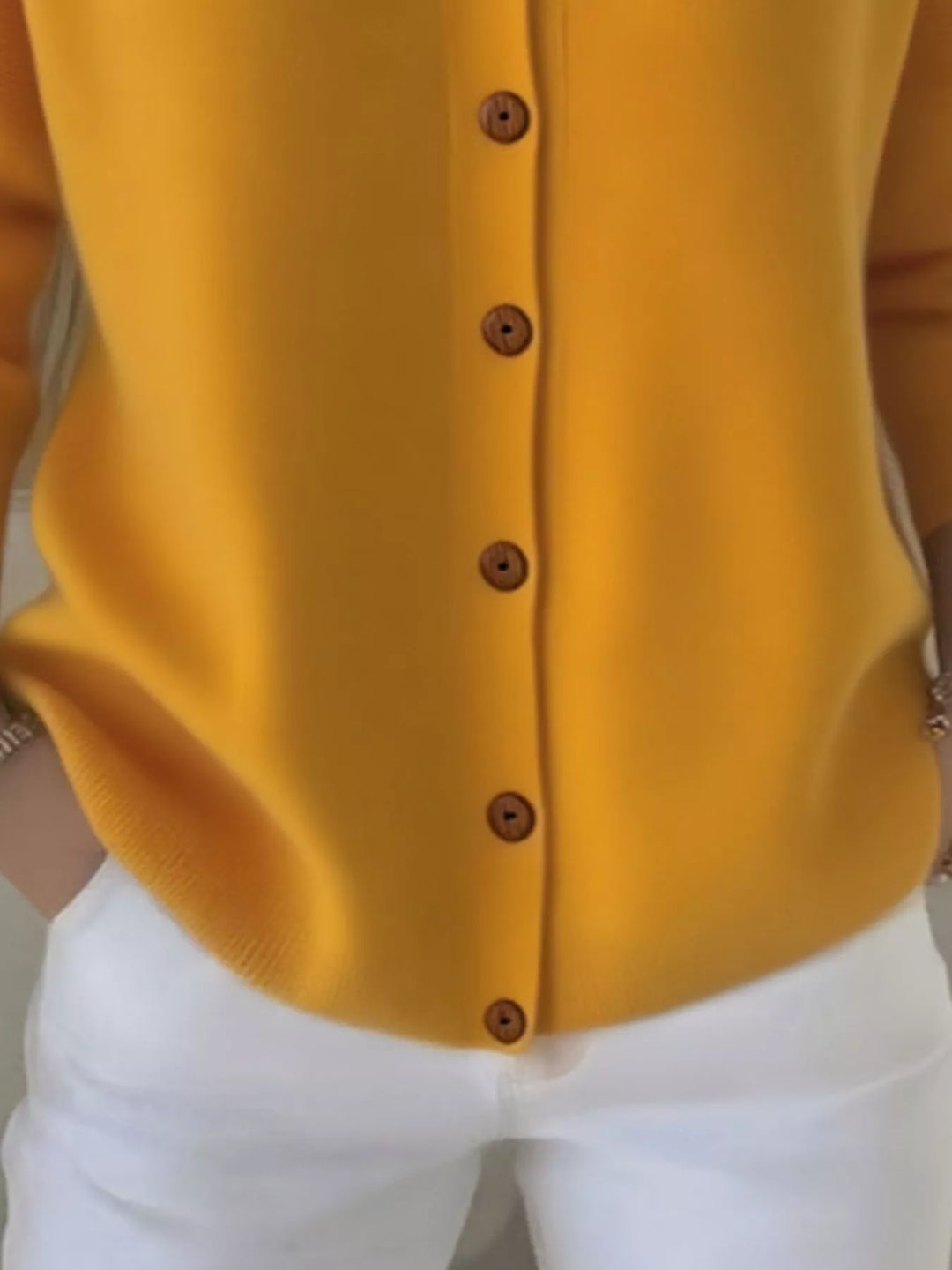 Close-up of the mustard yellow cardigan hood and V neckline