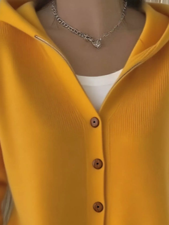 Detail of the mustard yellow cardigan button front and ribbed hem