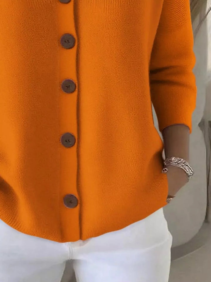 Detail of the orange cardigan button front and ribbed hem