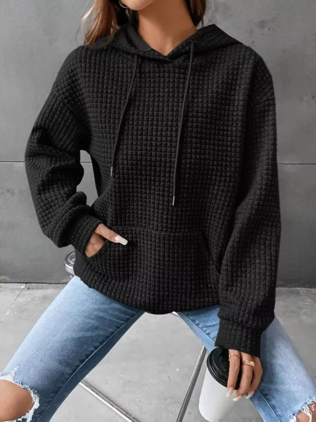 Waffle texture kangaroo pocket drawstring hood in black, front view