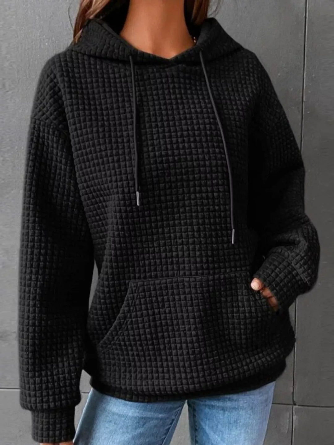 Waffle texture kangaroo pocket drawstring hood in black, styled on model