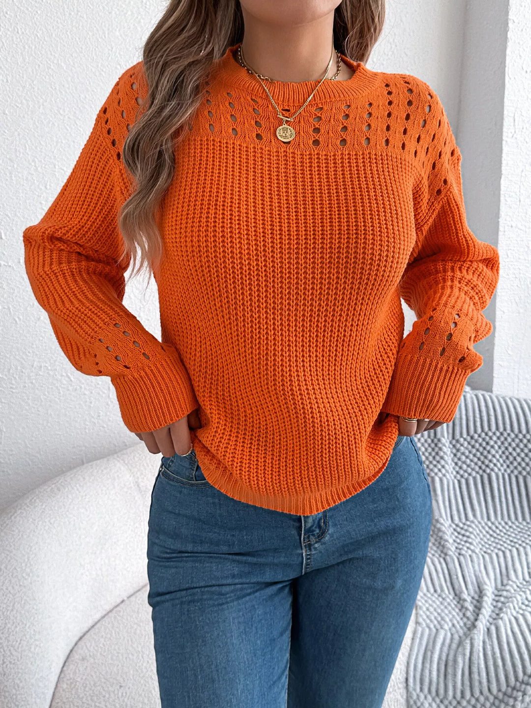 Orange pullover close up of the cutout yoke and pendant necklace