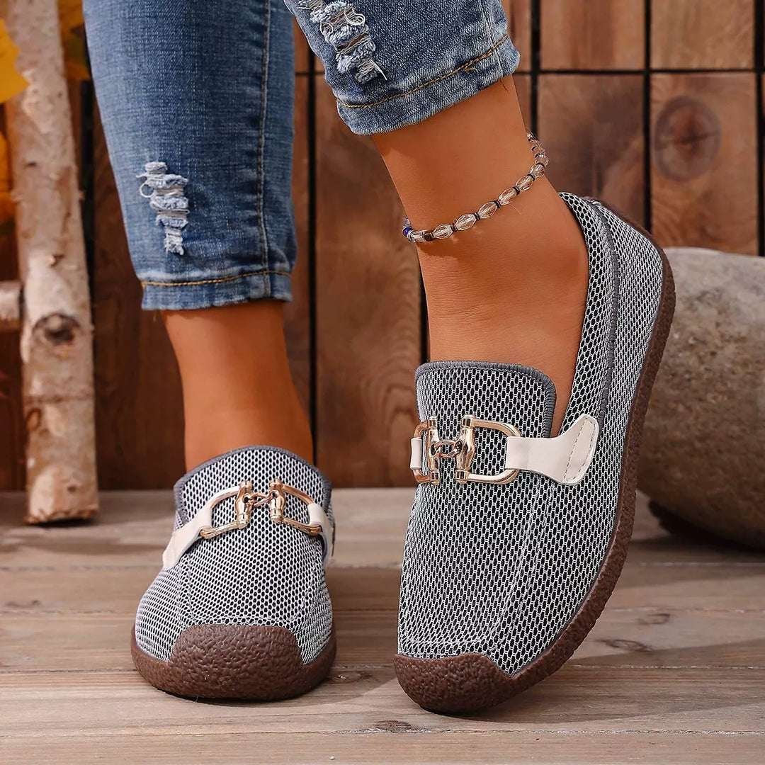 Gray buckle flats front view worn with ripped jeans and an anklet