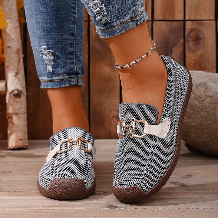 Gray buckle flats front view worn with ripped jeans and an anklet