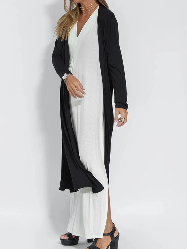 Black open front long cardigan in a side view over a white dress