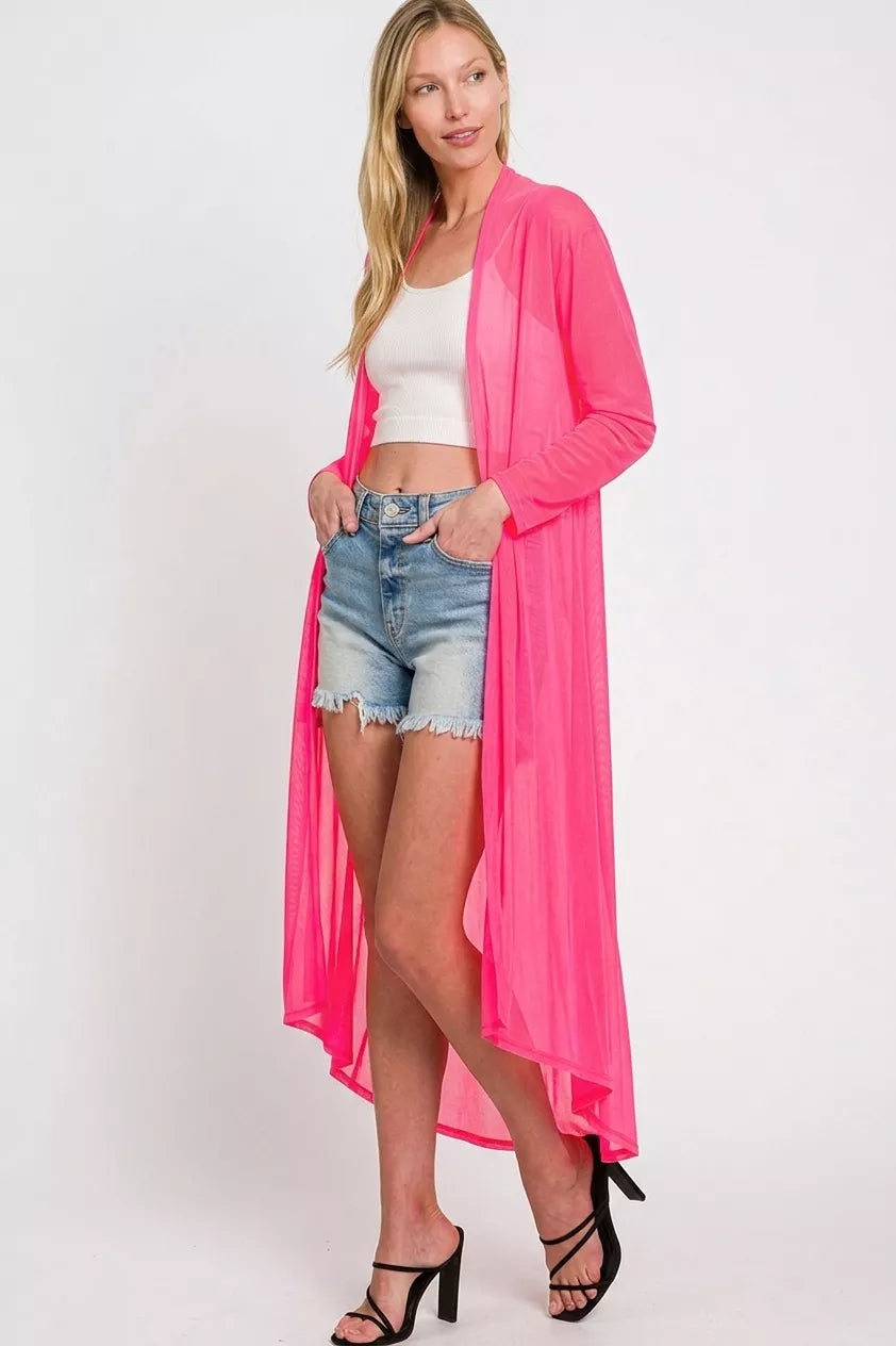 Hot pink mesh long cardigan on a gray backdrop, hands in pockets