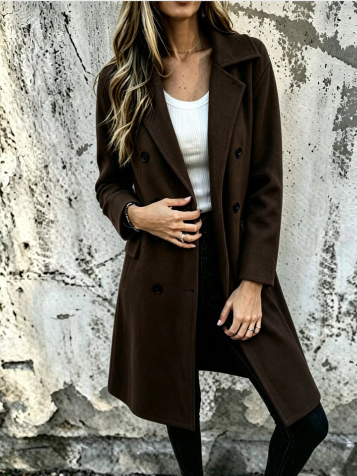 Dark brown double breasted long coat worn over a white top