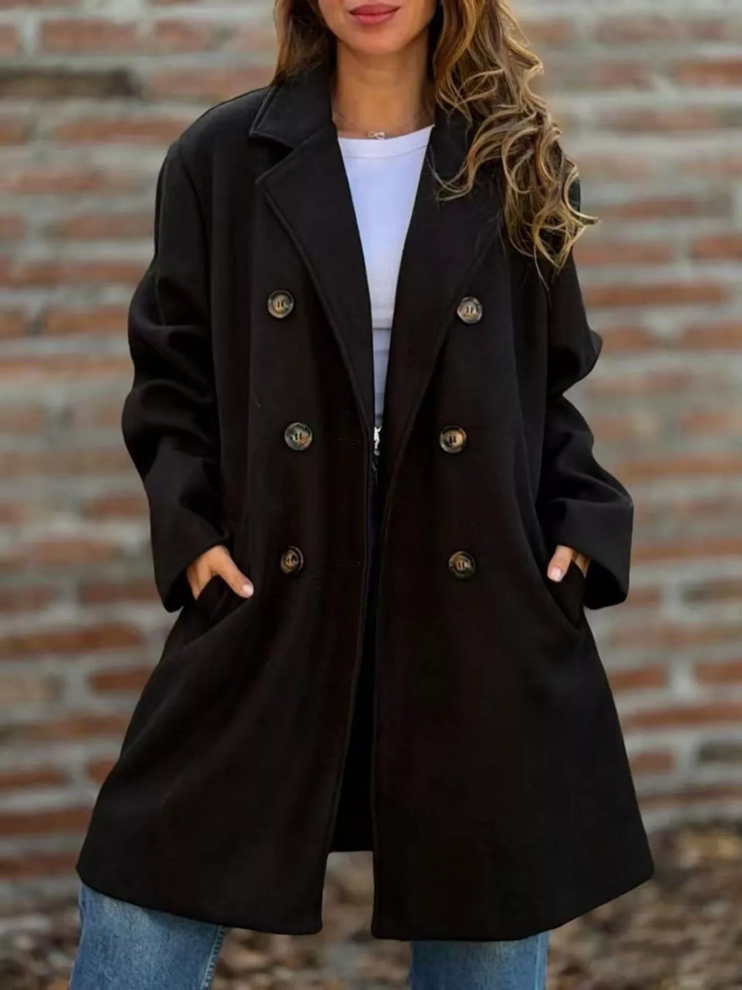 Black long coat buttoned front with hands in pockets over a white tee