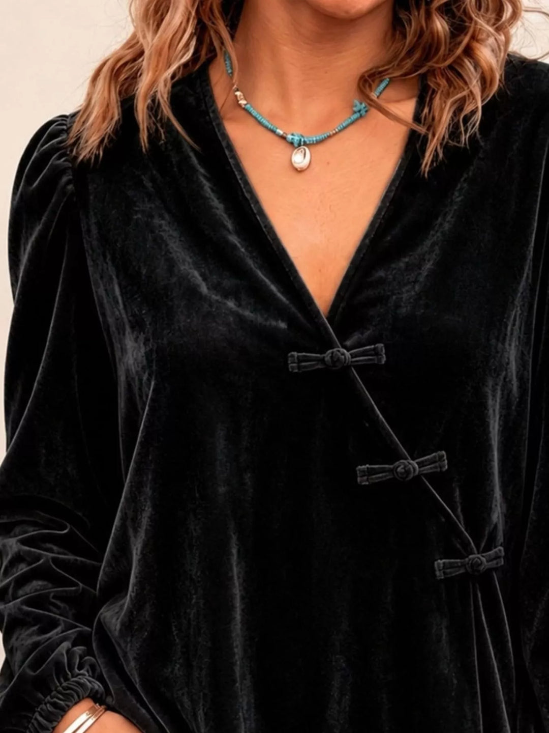 Velvet-look knot button puff sleeve in black, styled on model