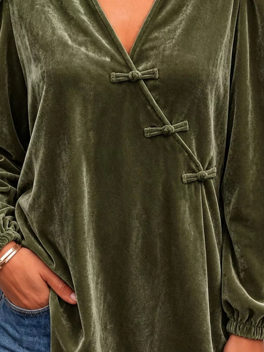 Velvet-look knot button puff sleeve in dark green, close-up detail