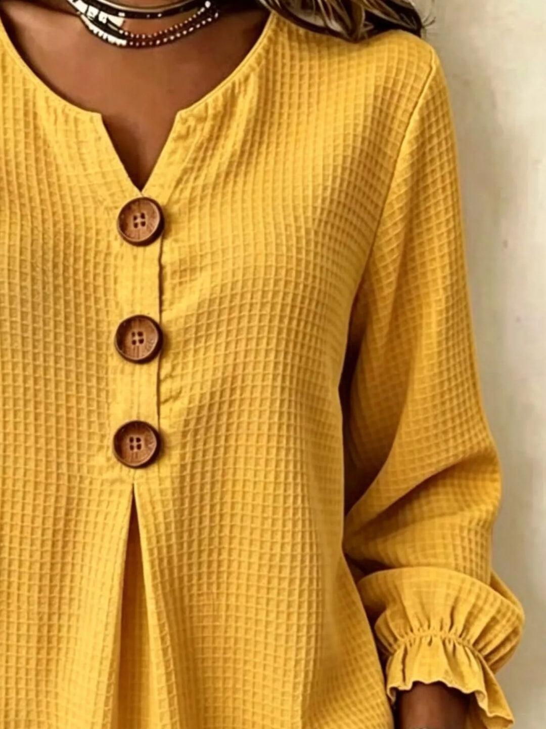 Waffle knit notched v-neck big buttons in mustard, close-up detail