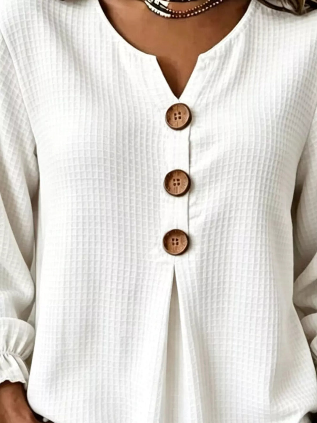 Waffle knit notched v-neck big buttons in white, close-up detail
