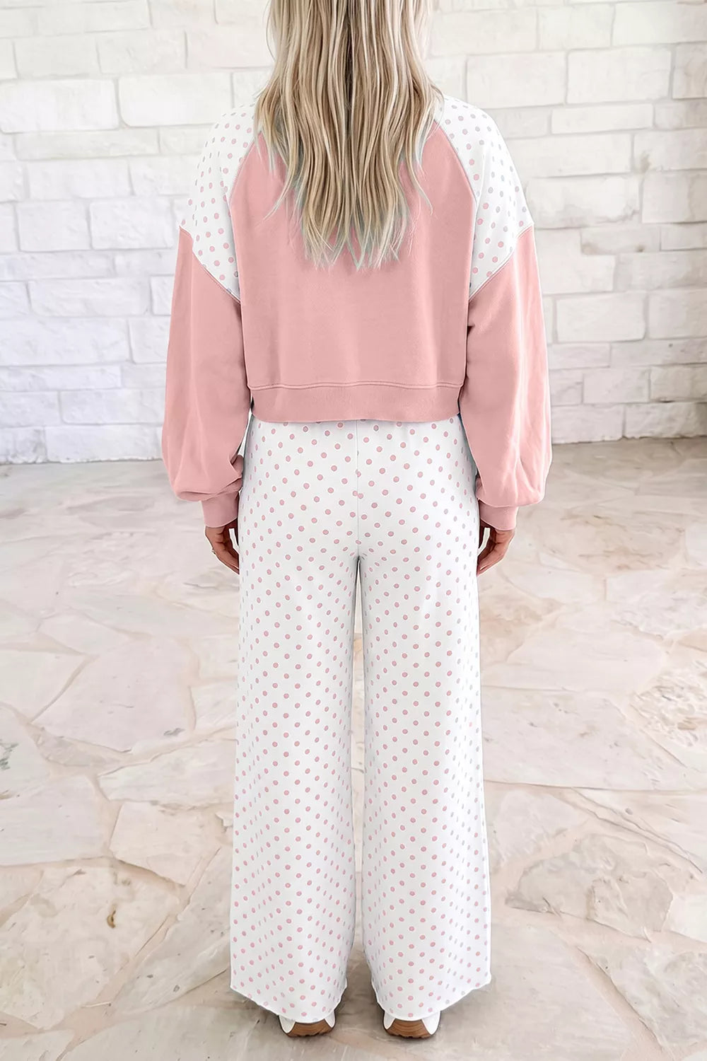 Back view of the blush cropped sweatshirt and polka dot wide pants