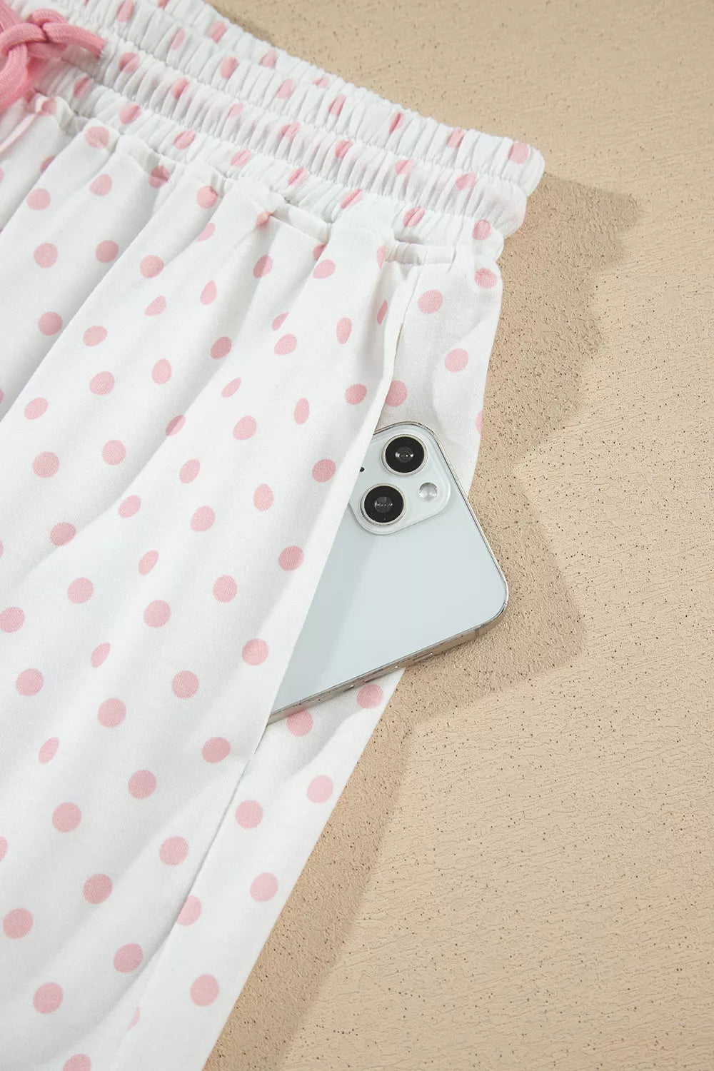 Side pocket of the polka dot pants holding a phone
