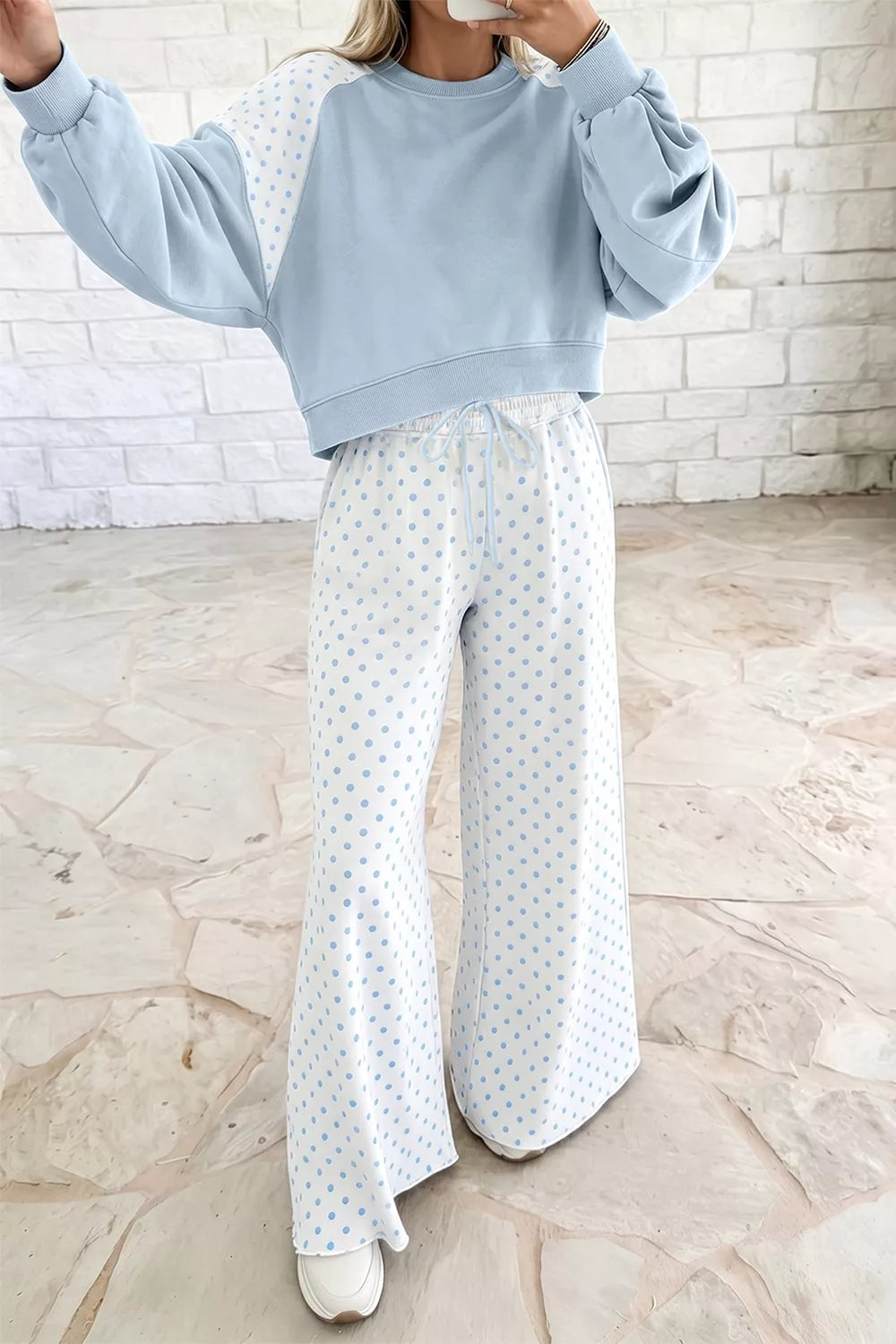 Light blue lounge set with arm raised, showing the cropped sweatshirt fit