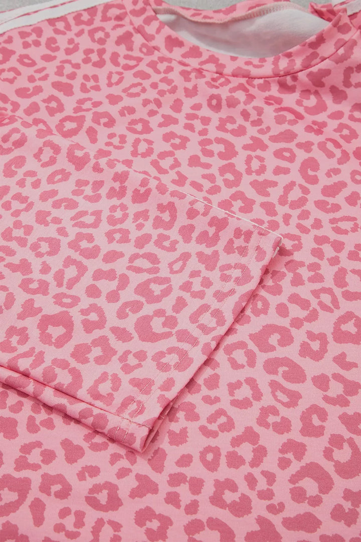 Pink leopard print sleeve and top fabric laid flat, close-up