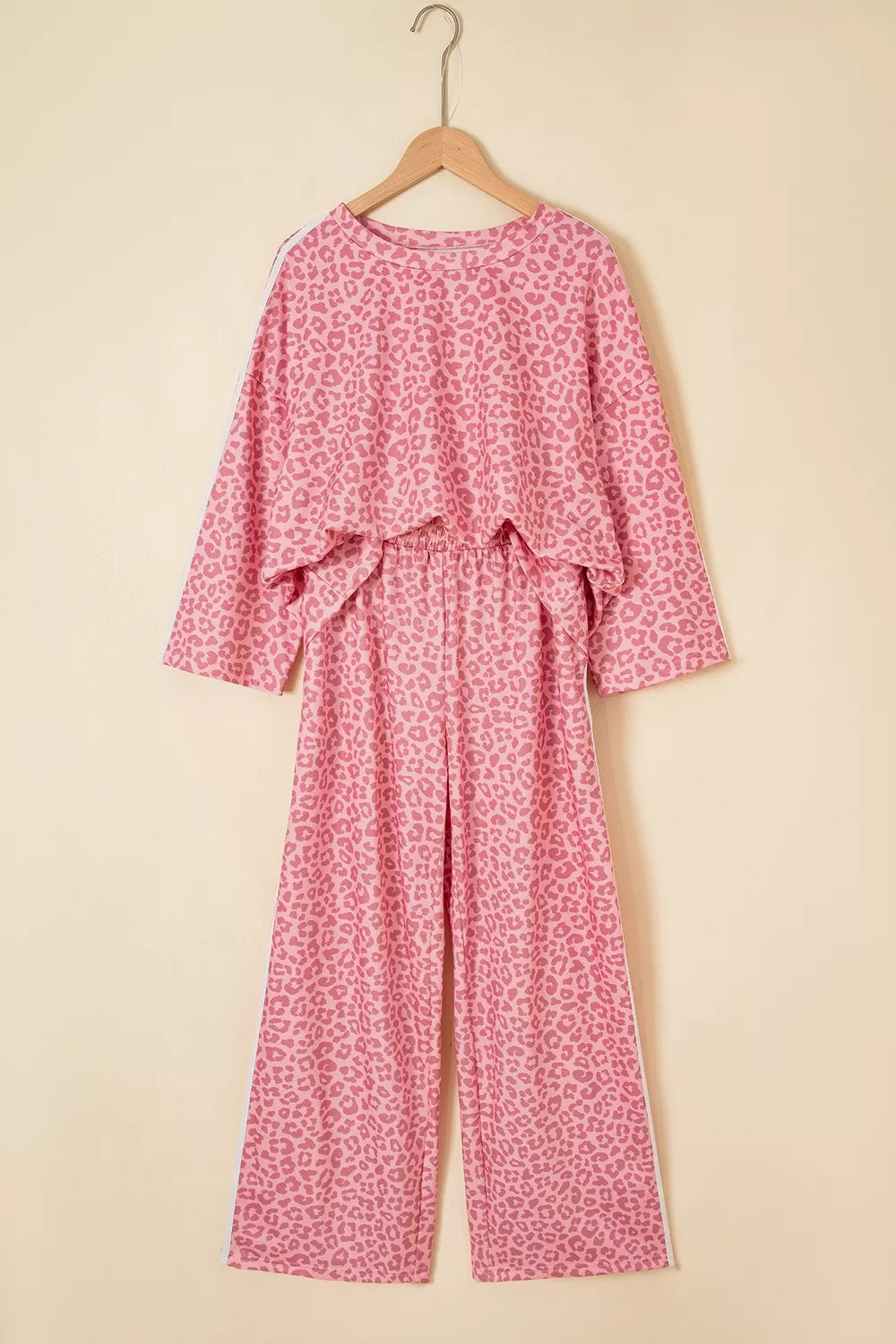 Pink leopard print lounge set hanging with long sleeve top and wide leg pants, front