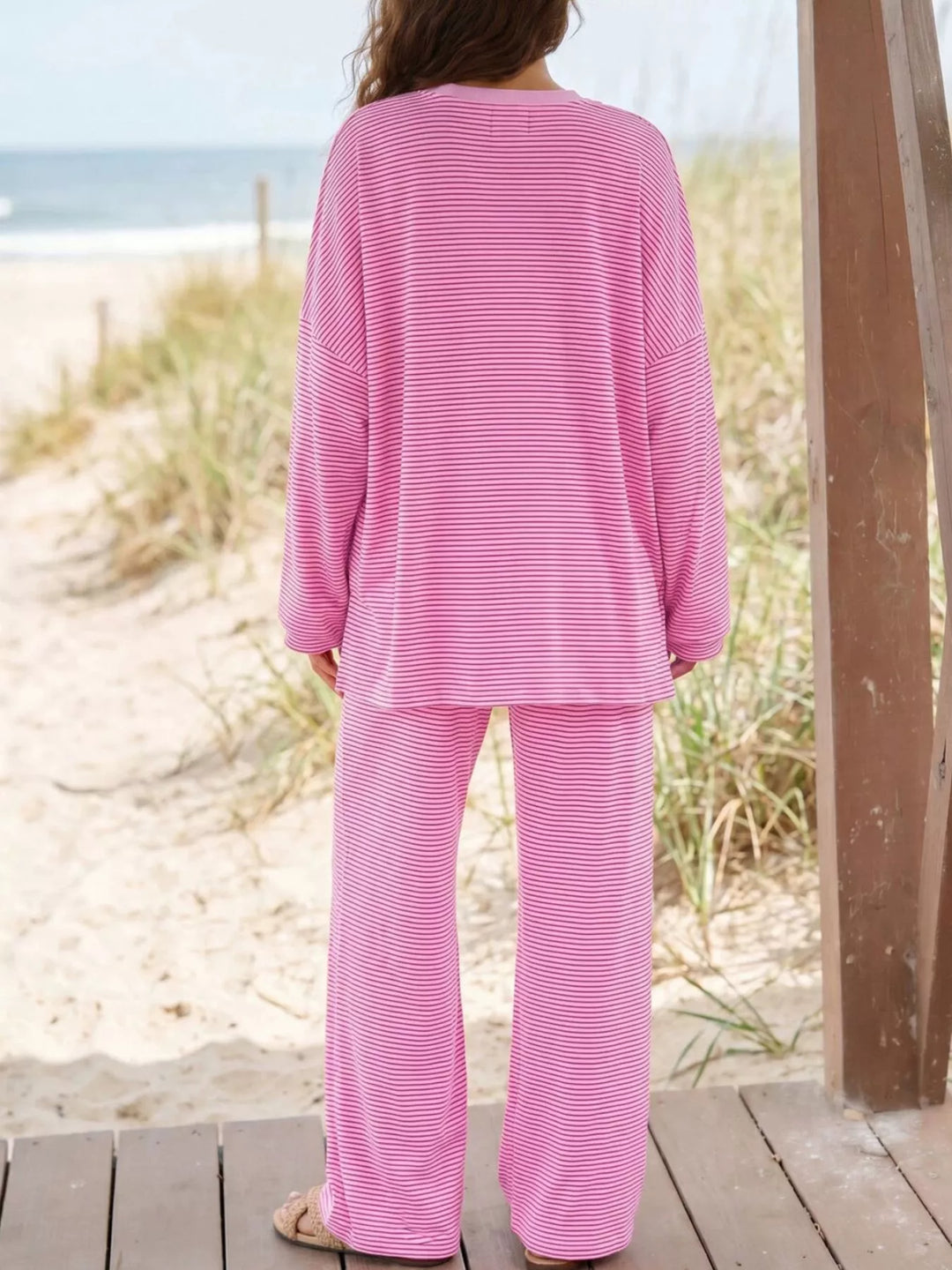 Pink lounge set seen from behind on a beach boardwalk