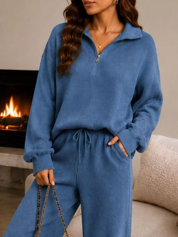 Dusty blue ribbed quarter zip top and pants, closer three quarter view