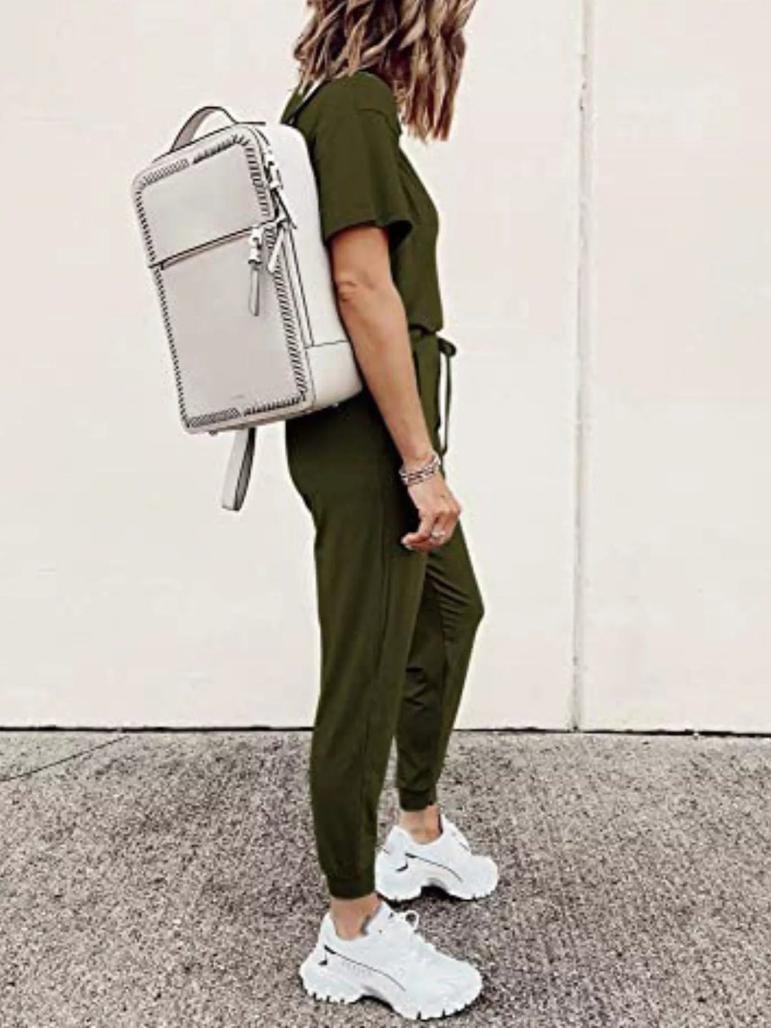 Army green short sleeve tee and jogger pants, side view with a backpack
