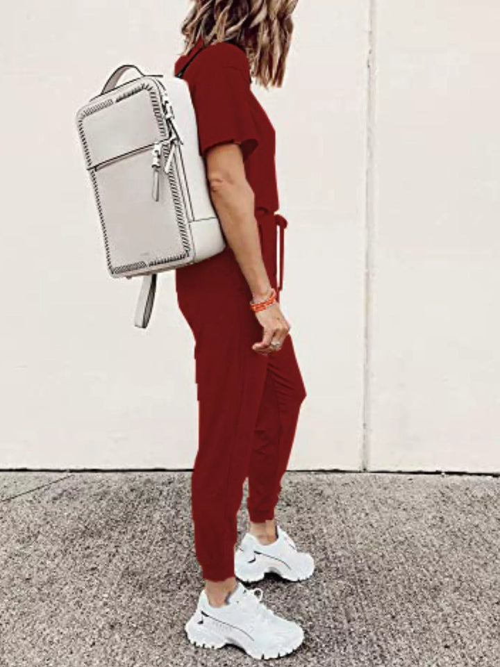 Burgundy tee and jogger set seen from the side with a white backpack