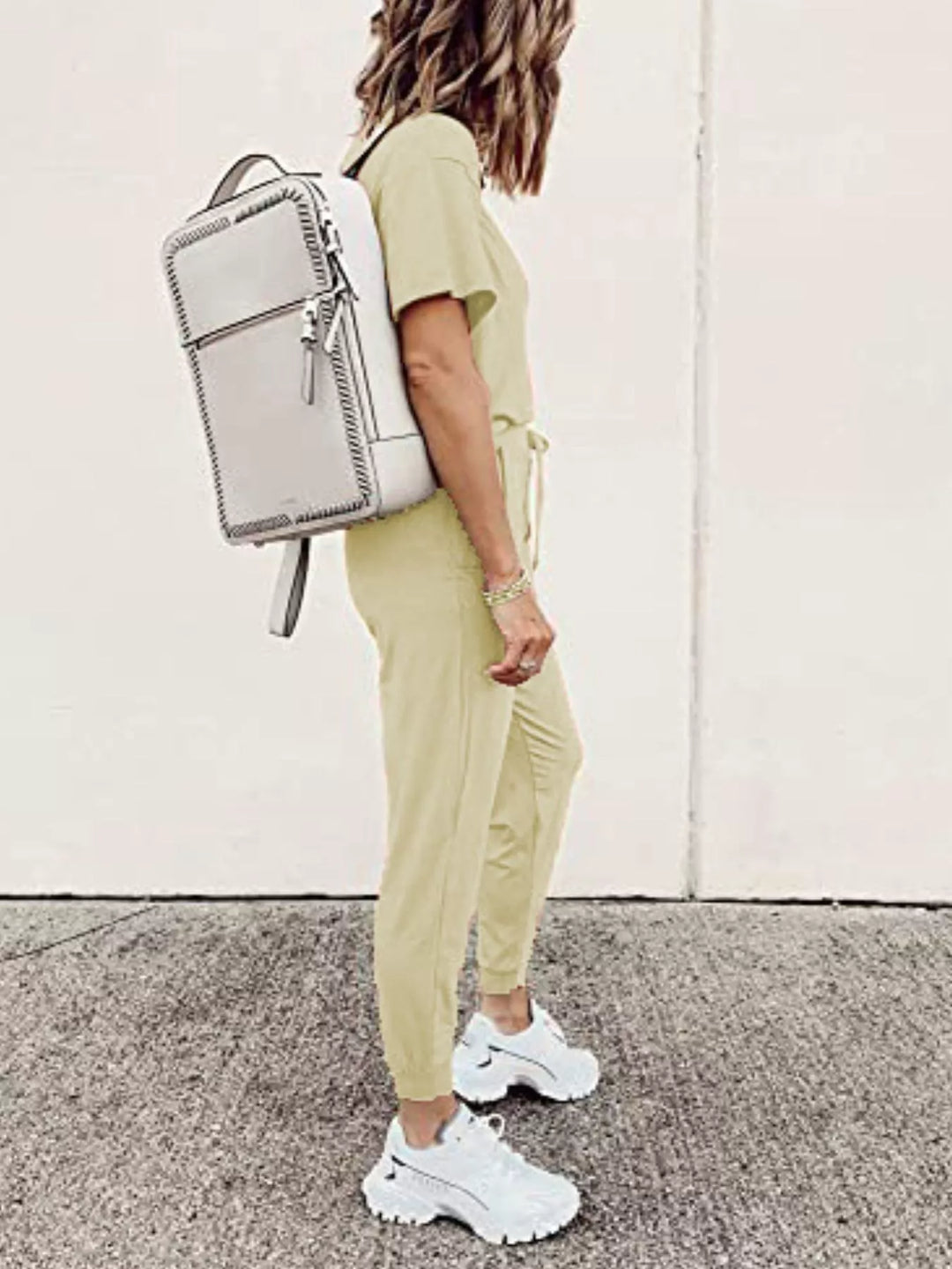 Butter yellow tee and joggers outfit with a white backpack, side view